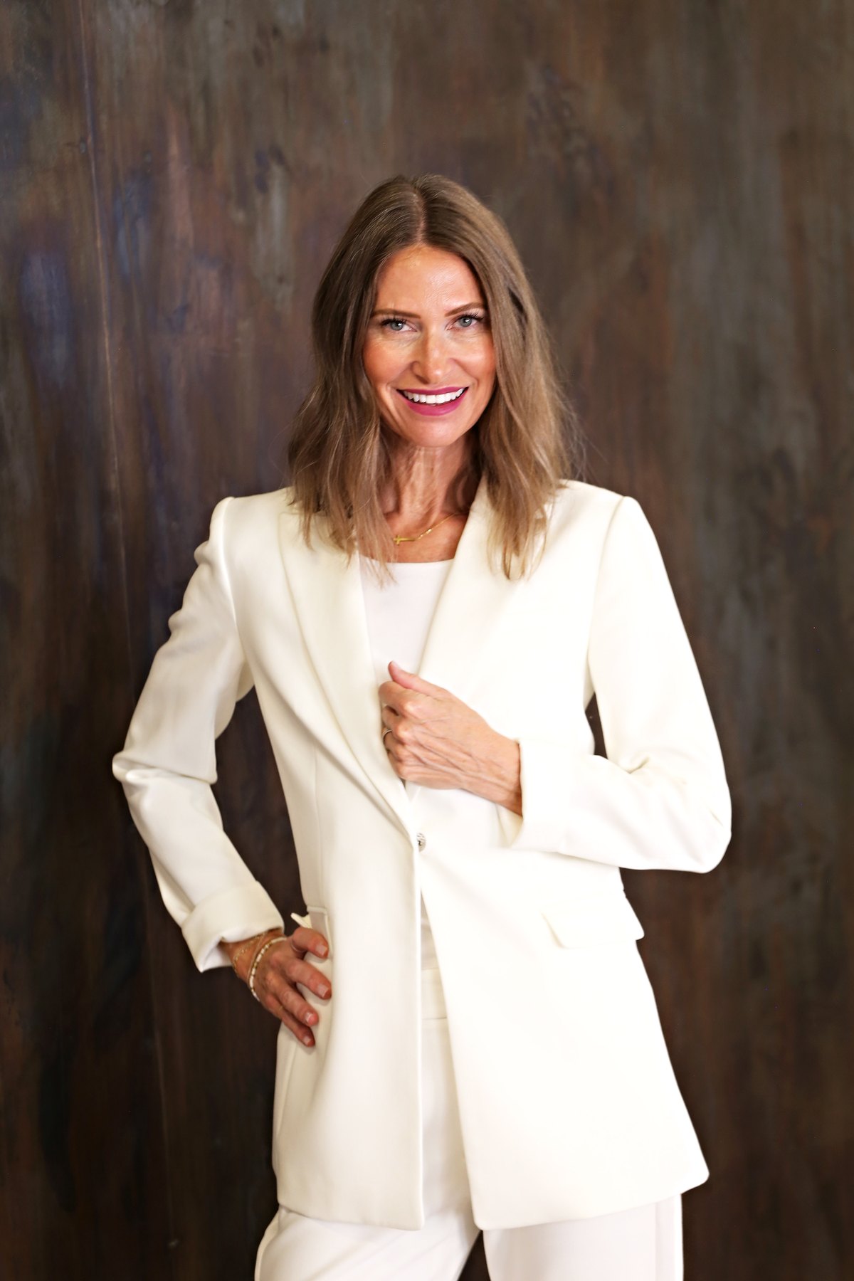 Ganel-Lyn Condie smiling in a white suit